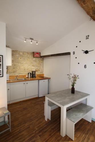une cuisine avec une table et un comptoir dans l'établissement La Sonnette B&B, à Ventouse