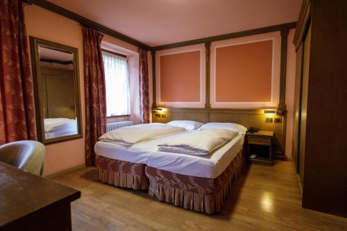 a bedroom with a large bed with a window at Hotel Compagnoni in Livigno