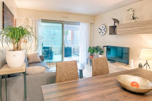 un salon avec une table à manger et une télévision dans l'établissement Residence du Palais Nil, à Nice