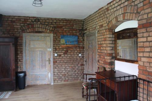 an empty room with brick walls and two doors at Siedlisko Gizewo in Gizewo