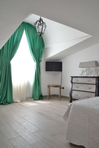 a bedroom with green curtains and a bed and a dresser at B&B Cloud in Santa Maria Capua Vetere