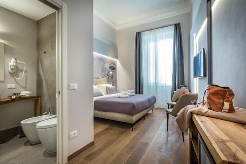 フィレンツェにあるPalazzo dei Conti Residenza d'Epocaのベッドとバスルーム付きのホテルルームです。