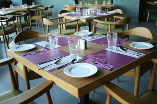 a wooden table with plates and napkins on it at Regenta Central Harsha Vapi in Vapi
