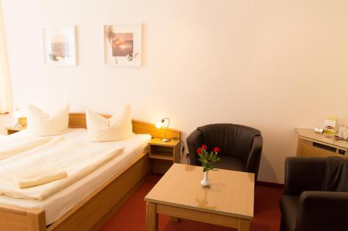 a hotel room with a bed and a table at Pension Haus Waldesblick in Graal-Müritz