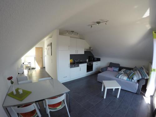 a living room and kitchen with a couch and a table at Ferienhaus Talblick in Kelberg