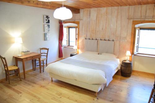 une chambre avec un lit, une table et des chaises dans l'établissement Le Moulin du Bateau - Maison d'hôtes, à Léotoing