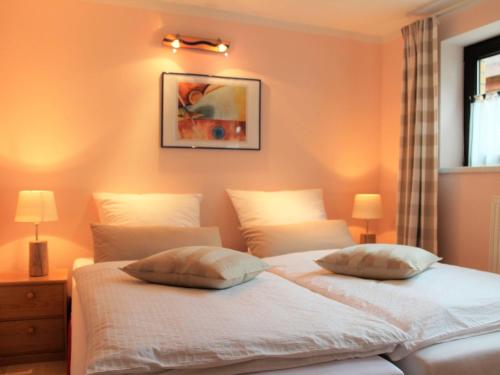 オストゼーバート・ニーンハーゲンにあるModern Apartment in Nienhagen with Terrace, Garden, Barbecueのオレンジ色の壁のベッドルームにツインベッド2台が備わります。
