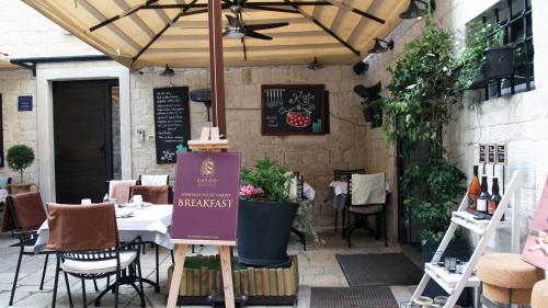 a restaurant with a table with a sign in front of it at Heritage Hotel Cardo in Split