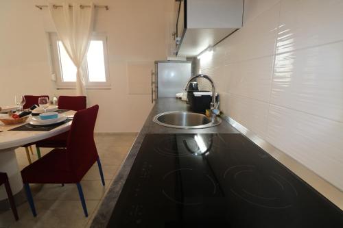 kuchnia ze zlewem i stołem z krzesłami w obiekcie Apartman La maison w mieście Zadar
