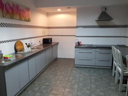 a large kitchen with white cabinets and a sink at Marcus in Bydgoszcz