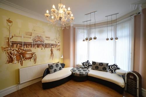 a living room with two chairs and a chandelier at The Winter Garden Suites in Blackpool
