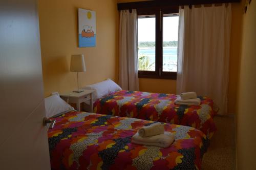 Un dormitorio con dos camas con toallas encima. en WHITE - EnjoytheSeainColonia WE RENT ONLY FROM SAT TO SAT, en Colonia de Sant Jordi