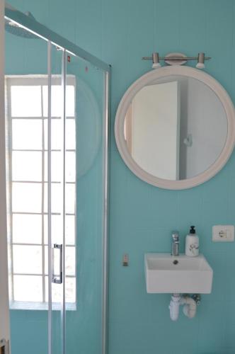 Un baño azul con lavabo y espejo. en WHITE - EnjoytheSeainColonia WE RENT ONLY FROM SAT TO SAT, en Colonia de Sant Jordi