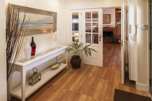 una sala de estar con una mesa con jarrones y una planta en Villa Gerbera, en Apostiça