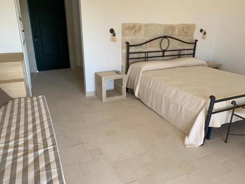 1 dormitorio con 2 camas y suelo de baldosa en Agriturismo Messer Gesualdo, en Nociglia