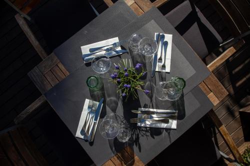 een tafel met glazen en een vaas met bloemen erop bij Hotel Arancioamaro in Cannero Riviera