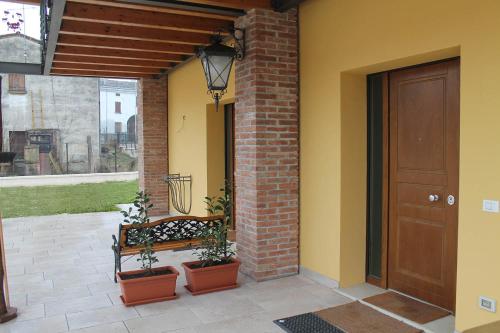 un porche con un banco junto a una puerta en Corte Nuova B&B, en Bagnolo San Vito