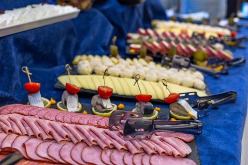 a table topped with sausages and onions and other foods at Rizzo Boutique Hotel in Poiana Brasov
