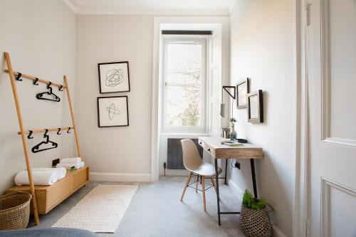 een kamer met een bureau, een bed en een raam bij Holyrood Park City Centre Apartment in Edinburgh