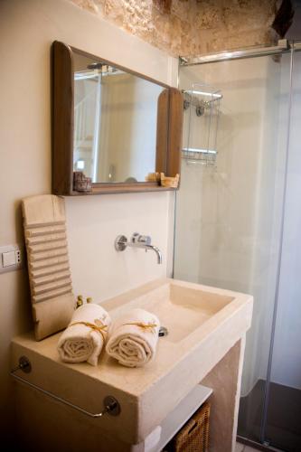 a bathroom with a sink with a mirror and a shower at Nenètte in Locorotondo