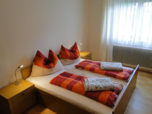 - une chambre avec 2 lits jumeaux et des oreillers colorés dans l'établissement Apartment Ferienwohnung Kogler, à Kraig
