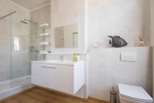 a white bathroom with a sink and a shower at Restaurant & Guesthouse Cachet de Cire in Turnhout