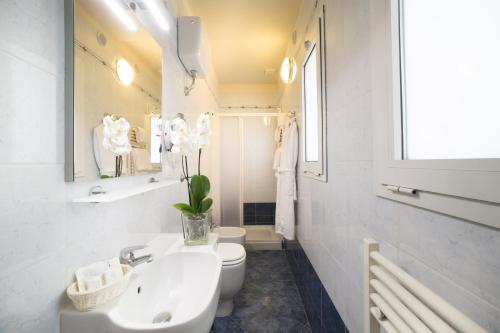 a white bathroom with a sink and a toilet at Hotel Montreal in Florence