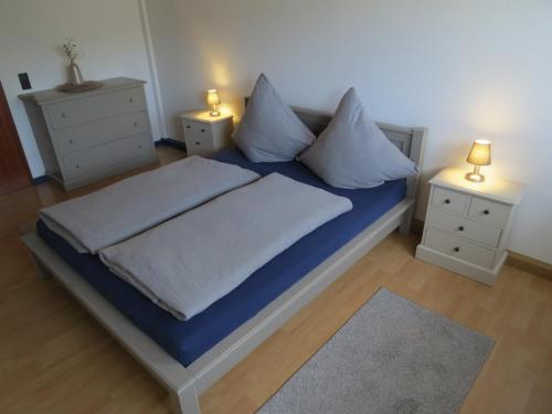 Schlafzimmer mit einem Bett mit blauer Bettwäsche und Kissen in der Unterkunft Ferienwohnung am Gässle in Ettenheim