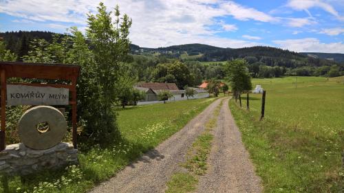a dirt road in a field with a sign at Kovářův mlýn in Stachy