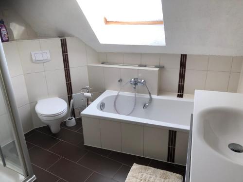 a bathroom with a toilet and a tub and a sink at Ferienwohnung am Rande der Dübener Heide in Laußig