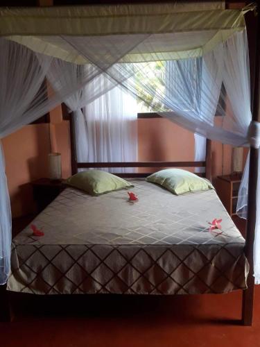 a bedroom with a canopy bed with flowers on it at Hotel Nautile in Sainte Marie