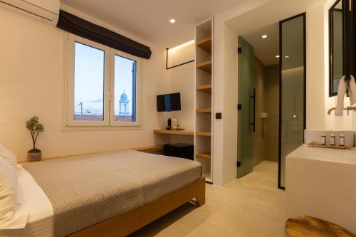 a bedroom with a bed and a sink and a window at Eleana Hotel in Tinos Town