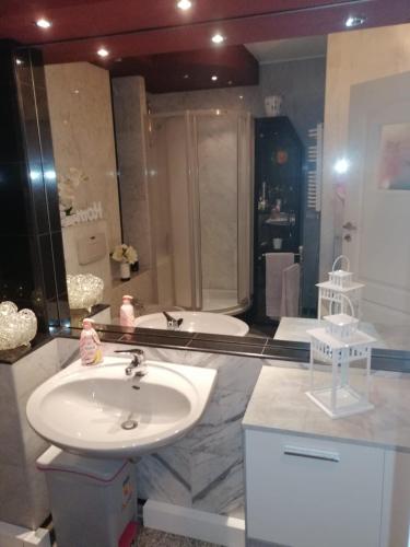 a bathroom with a sink and a tub at Apartament Paradise in Międzyzdroje
