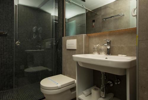 a bathroom with a toilet and a sink and a shower at BOUTIQUE 25h by Eva stay 018 in Niš