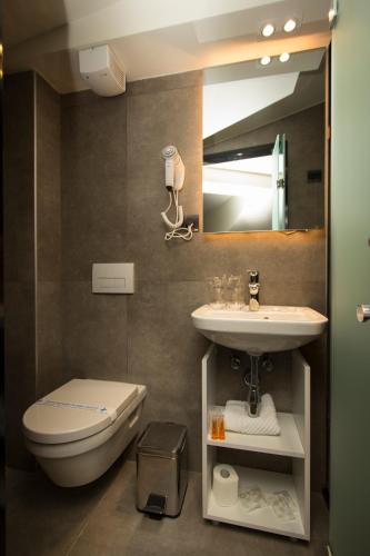 a bathroom with a sink and a toilet and a mirror at BOUTIQUE 25h by Eva stay 018 in Niš