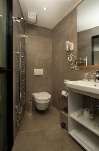 a bathroom with a toilet and a sink at BOUTIQUE 25h by Eva stay 018 in Niš