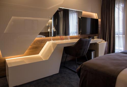 a hotel room with a desk and a bed at BOUTIQUE 25h by Eva stay 018 in Niš