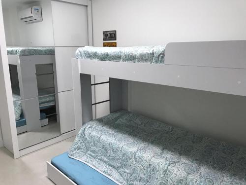 a bedroom with two bunk beds and a mirror at Pedaço do Paraíso em Arraial do Cabo in Arraial do Cabo