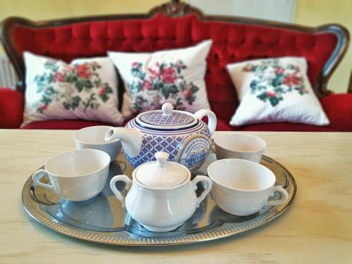 a tray with tea pots and cups on a table at Pałac w Krzelowie in Krzelów