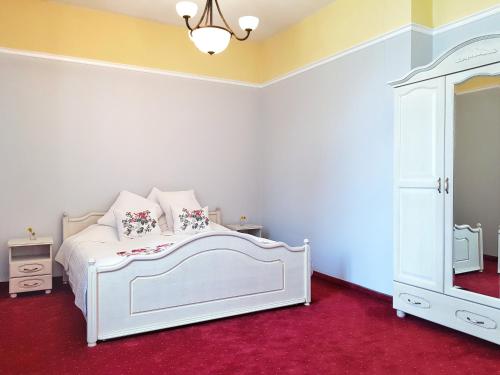 a bedroom with a white bed and a dresser at Pałac w Krzelowie in Krzelów