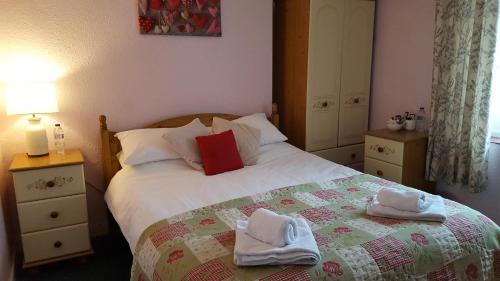 a bedroom with a bed with towels on it at The Bugle Inn in St Austell