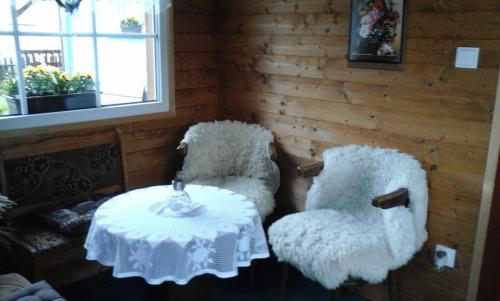 a room with a table and two white chairs and a table and a window at Modrý Dům in Horní Maršov