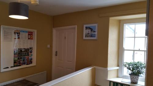 a hallway with a white door and a window at The Bugle Inn in St Austell