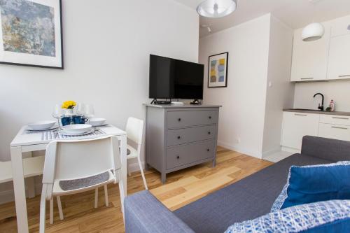 a small living room with a table and a tv at CR Kameralny Apartament przy Pałacu Branickich in Białystok