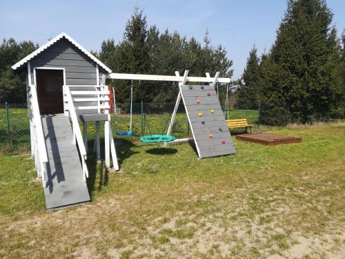 a playground with a slide and a play structure at Pod Gwiazdami in Władysławowo