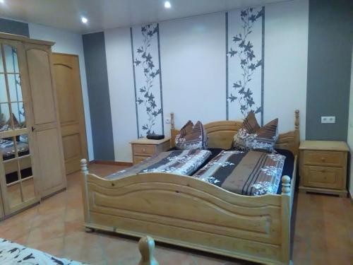 a bedroom with a wooden bed in a room at Gästehaus Kleine Lana in Obersuhl