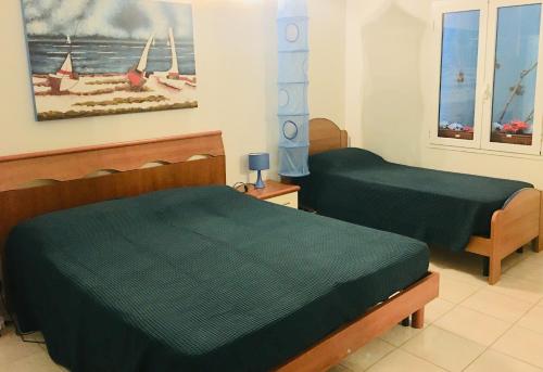 a bedroom with two beds and a painting on the wall at I Sentieri in Rio nellʼElba