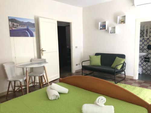 Habitación con cama, silla y espejo. en DolceVacanza, en Cefalú