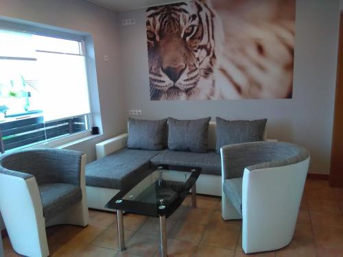 ein Wohnzimmer mit einem Sofa und einem Tigerfilm an der Wand in der Unterkunft Gästehaus Kleine Lana in Obersuhl