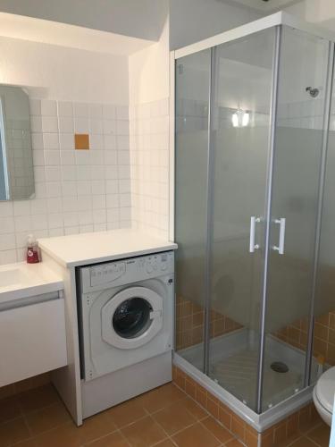 une machine à laver dans une salle de bain avec douche dans l'établissement AcquaMarina, à Villeneuve-Loubet
